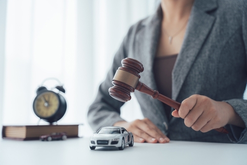 Model car beside judge gavel illustrating car accident lawsuit concept
